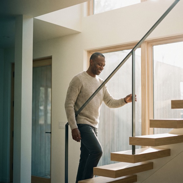 A man climbing stairs with a hand on the railing